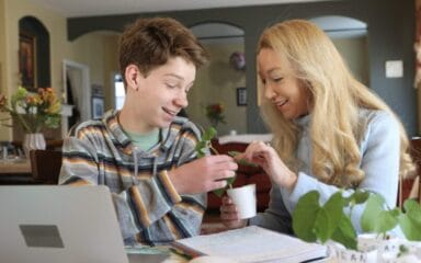 Mother and son working together on a science project with a plant